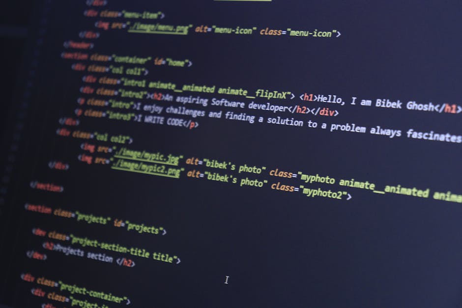 A close-up photograph of a computer screen displaying lines of computer code with multicolored syntax highlighting in green, orange, blue, and purple. The background is predominantly black, and the co